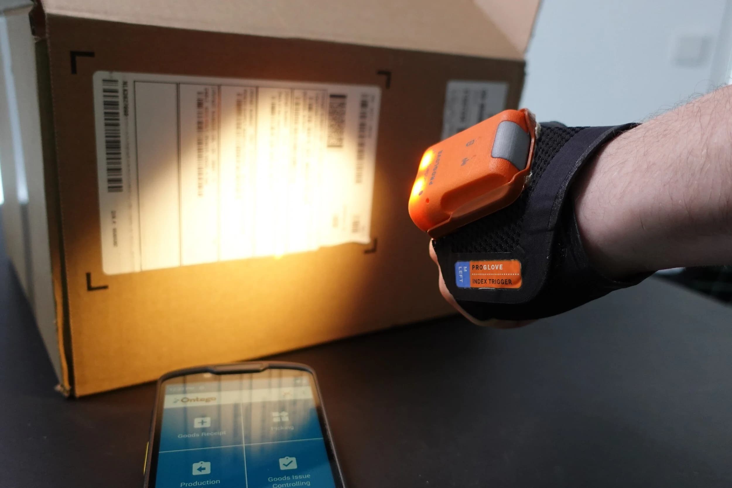 Worker using a back-of-hand scanner to scan an item barcode.